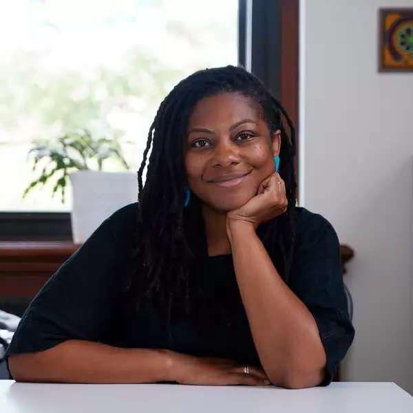 Tamara Walker smiling at desk in black top