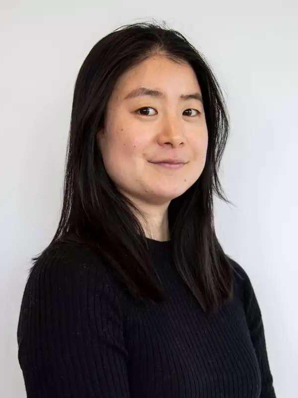 White background, woman smiling with black hair, black shirt