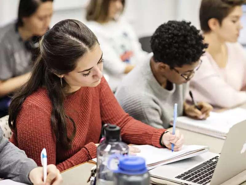 students in a classroom, writing in notebooks